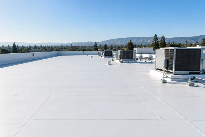 Illustrative: a white membrane commercial roof with Bay Area hills in the distance